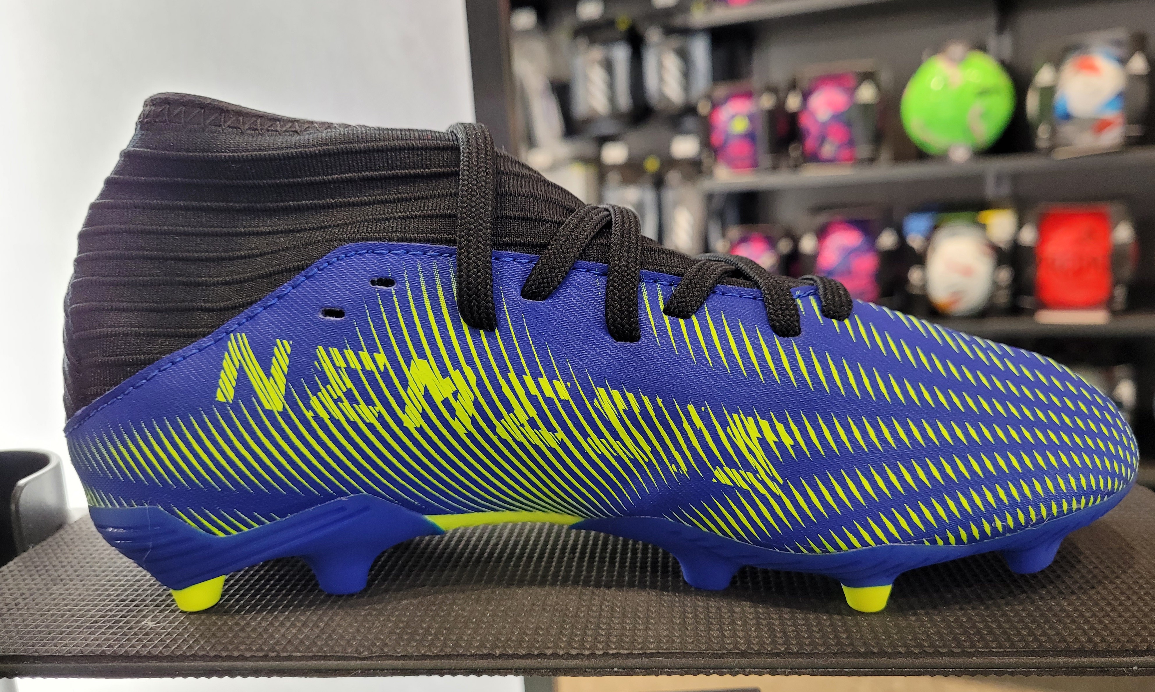 A picture of soccer cleats with the word NEMESIS on them