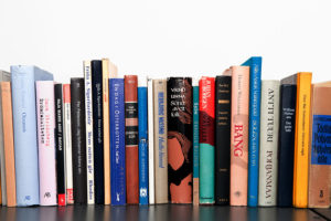 Hard-back books arranged on a shelf