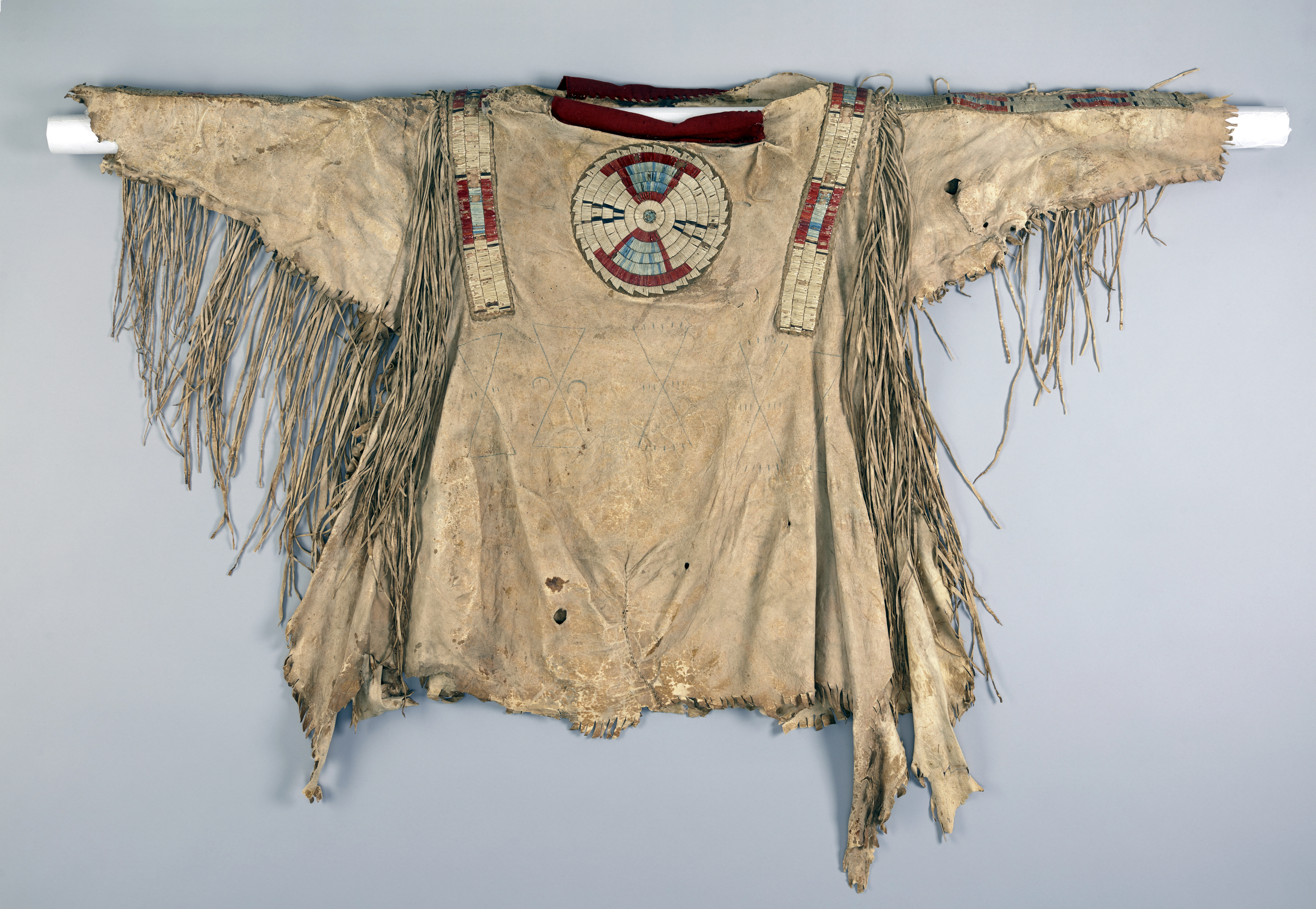 Quilled war shirt (front), c. 1800-1820. Native tanned hide, porcupine quills, red trade cloth, dyes, and sinew. 34 x 43 in. (Denver Art Museum)