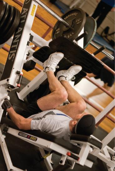 This photo shows a man exercising on a leg press machine at a gym.