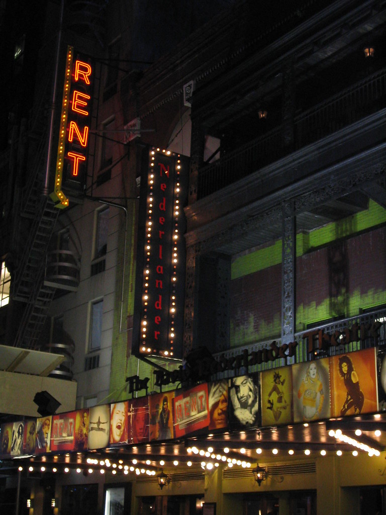 Exterior of the Nederlander Theatre. A sign mounted to the side of the building reads, "Rent."