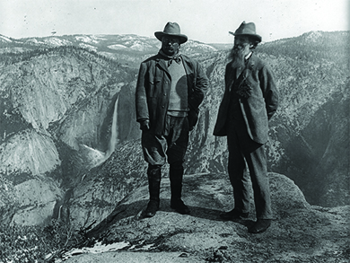 صورة فوتوغرافية تظهر ثيودور روزفلت وجون موير يقفان فوق منحدر في حديقة يوسمايت الوطنية.