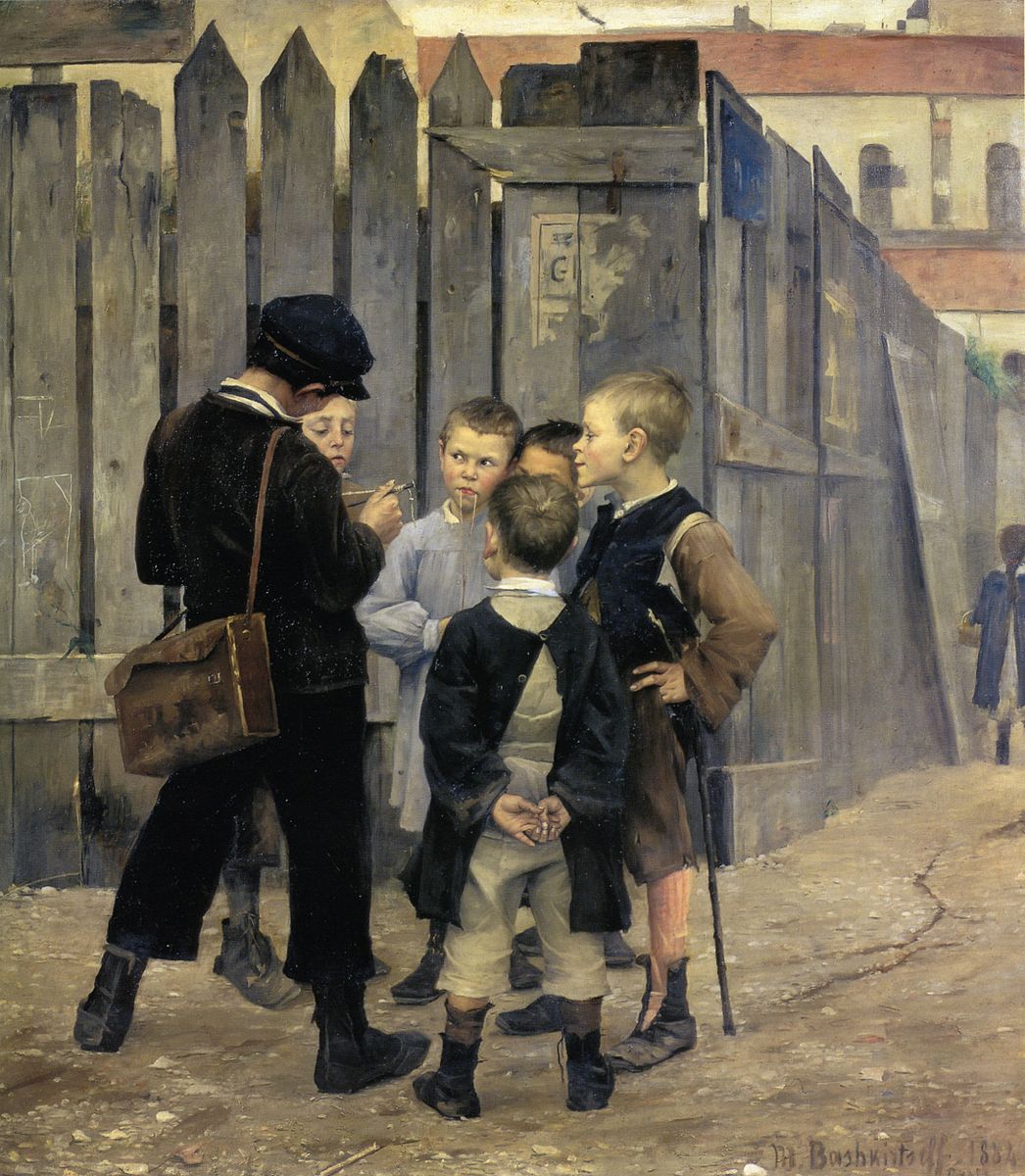 A group of young boys in a circle against a fence with a young girl to the extreme right