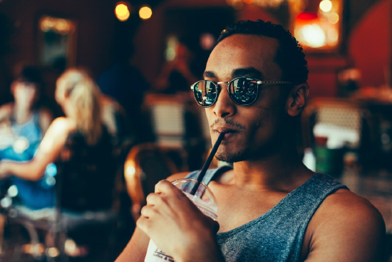 Image of man in sunglasses drinking