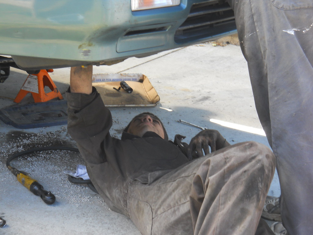 Image of mechanic working underneath a car