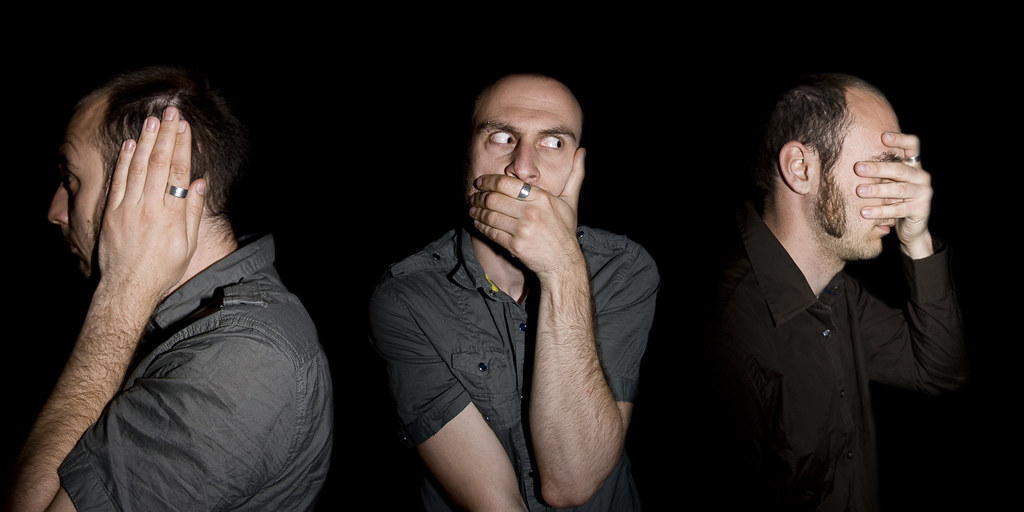 Image of a man acting out "Hear no evil, Speak no evil, and See no evil"