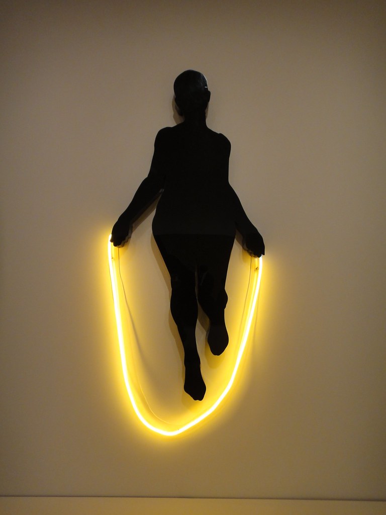 A silloute of a woman with a yellow jumprope