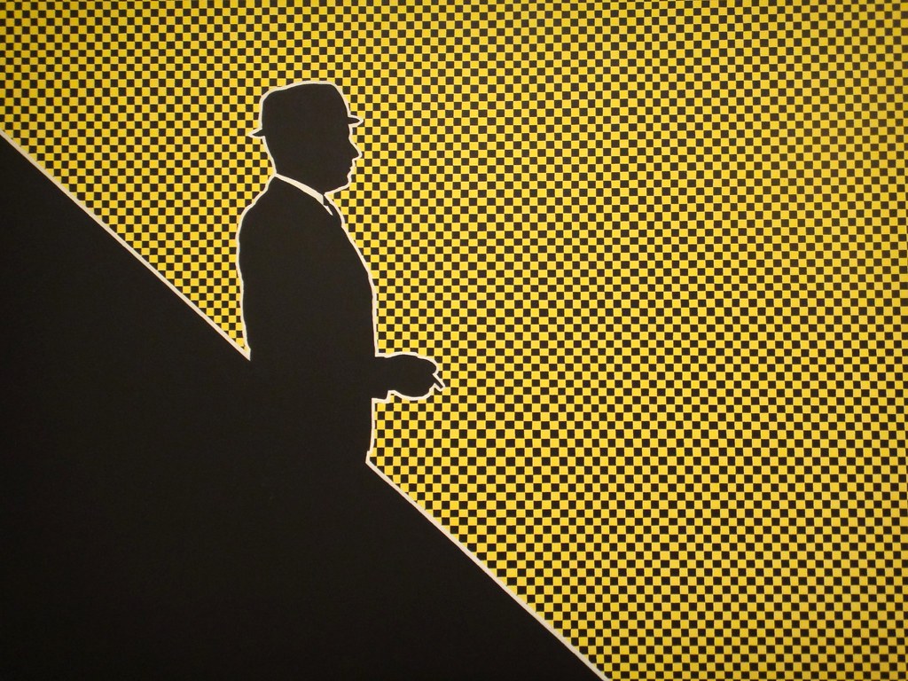 a silloute of a man again a yellow and black checkerboard
