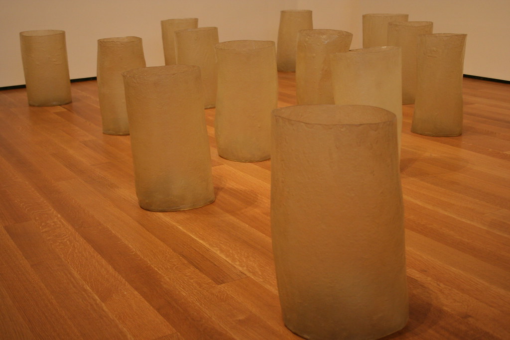 a sculpture of glass jars on a wooden floor