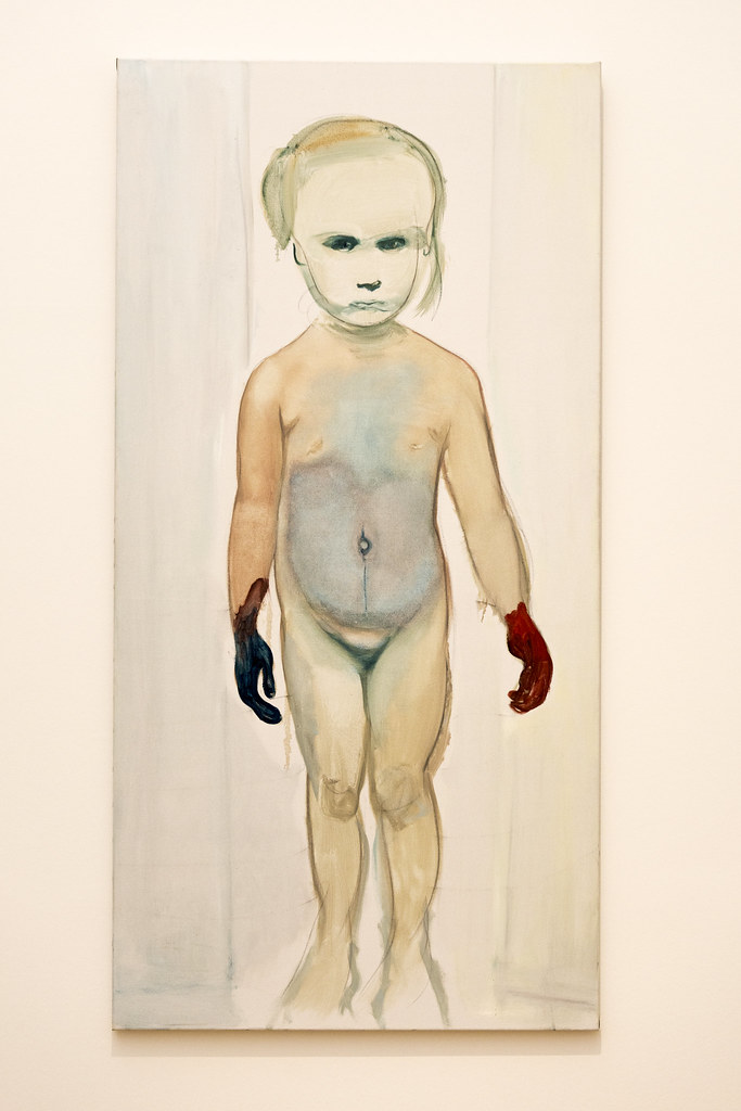a nude child with red and green paint on her hands