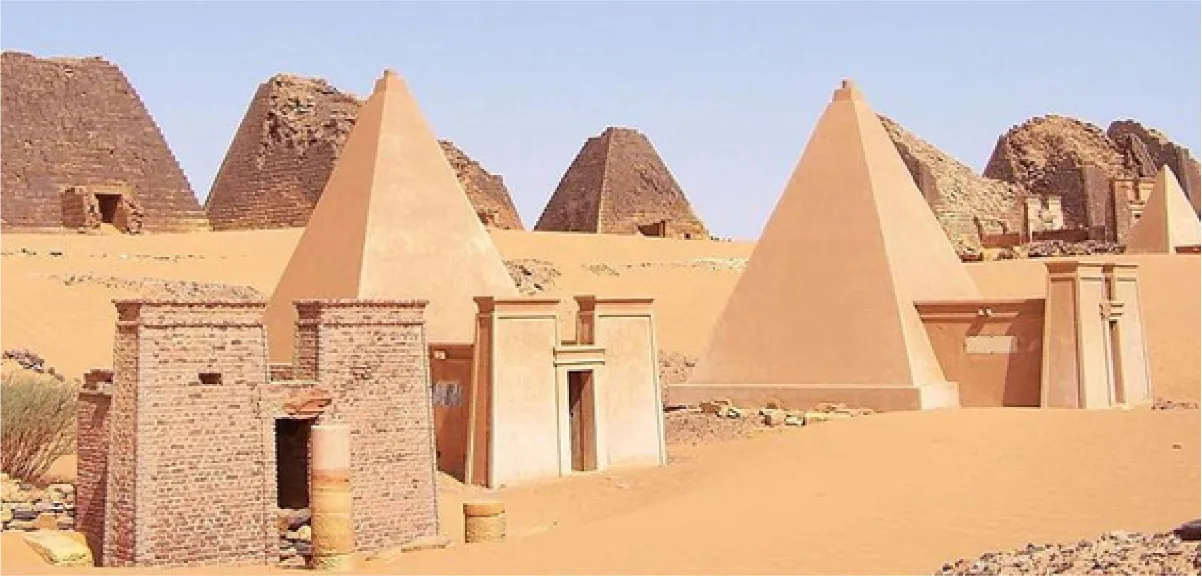 A picture of a sandy desert filled with small pyramids is shown. In the front there are two smooth pyramids with large, decorated, columned entryways in the front. In the left forefront there is a brick entryway that stands alone in front of a green bush. In the background there are five crumbling brick pyramids with simple doorways for openings. A smooth small pyramid is shown in the far right top of the picture. A clear blue sky shows in the background.