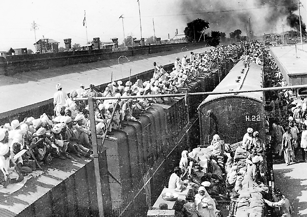Refugees crowded onto the tops of train cars while fleeing during the Partition.