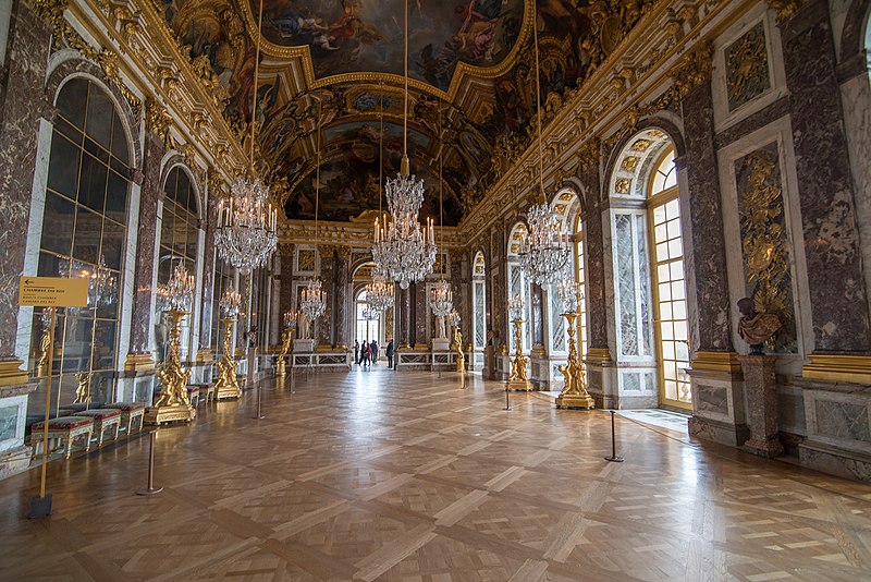 The Hall of Mirrors, bedecked in gilding and featuring several ornate chandeliers (in addition to the mirrors).