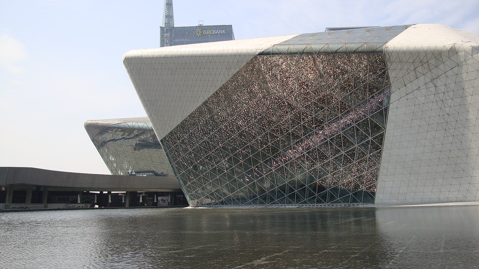 a building surrounded by water made of glass and stone