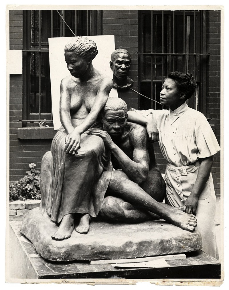 a bronze statue of a man and a woman with the artist leaning on the man