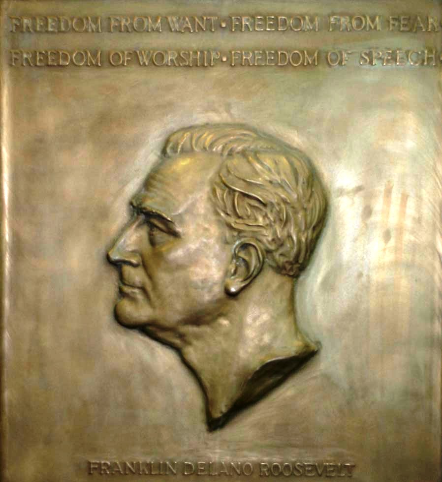 a bronze plaque with a relief of a mans head