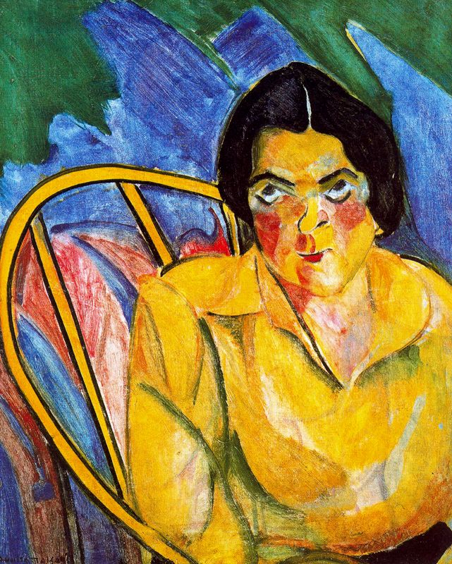 a woman with a yellow shirt sitting in a chair