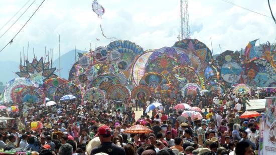 A crowd of people with large colorful objects - many circular, some stars or other shapes