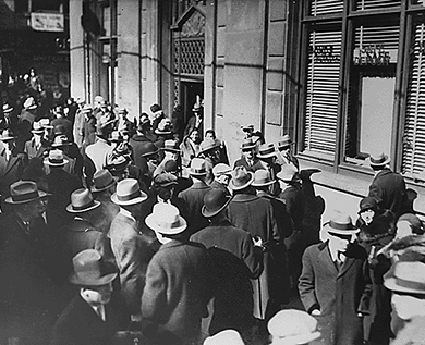 一张照片显示一大群男人和女人在银行外面等候。