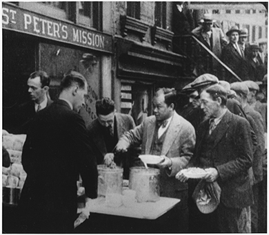 一张照片显示一排男子在纽约市圣彼得传教团前吃汤。