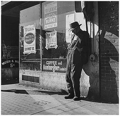 Une photographie montre un homme âgé démuni appuyé contre une devanture vacante à San Francisco, en Californie. La fenêtre est recouverte de panneaux indiquant diverses propriétés « à louer ».