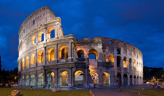 A photo of the Colosseum as it stands today, lit up at dusk.