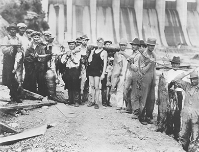 Una fotografía muestra a un grupo de trabajadores de TVA parados frente a la Presa Wilson.