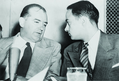 Uma fotografia mostra Joseph McCarthy e Roy Cohn em uma conversa silenciosa.