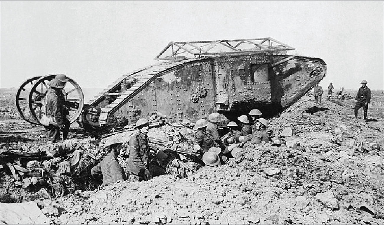 The photograph shows a tank. Several soldiers sand nearby in a trench nearby.