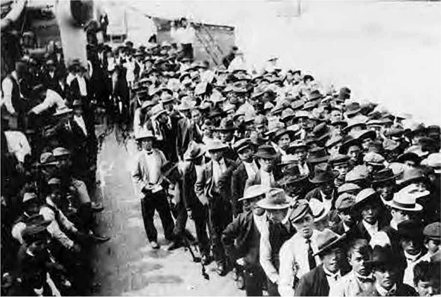 This photograph shows a large number of Japanese men standing on the deck of a ship. Most men wear hats and western style suits.