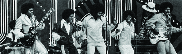 Une photographie montre les Jackson Five en spectacle. Chaque membre du groupe arbore une coiffure afro.