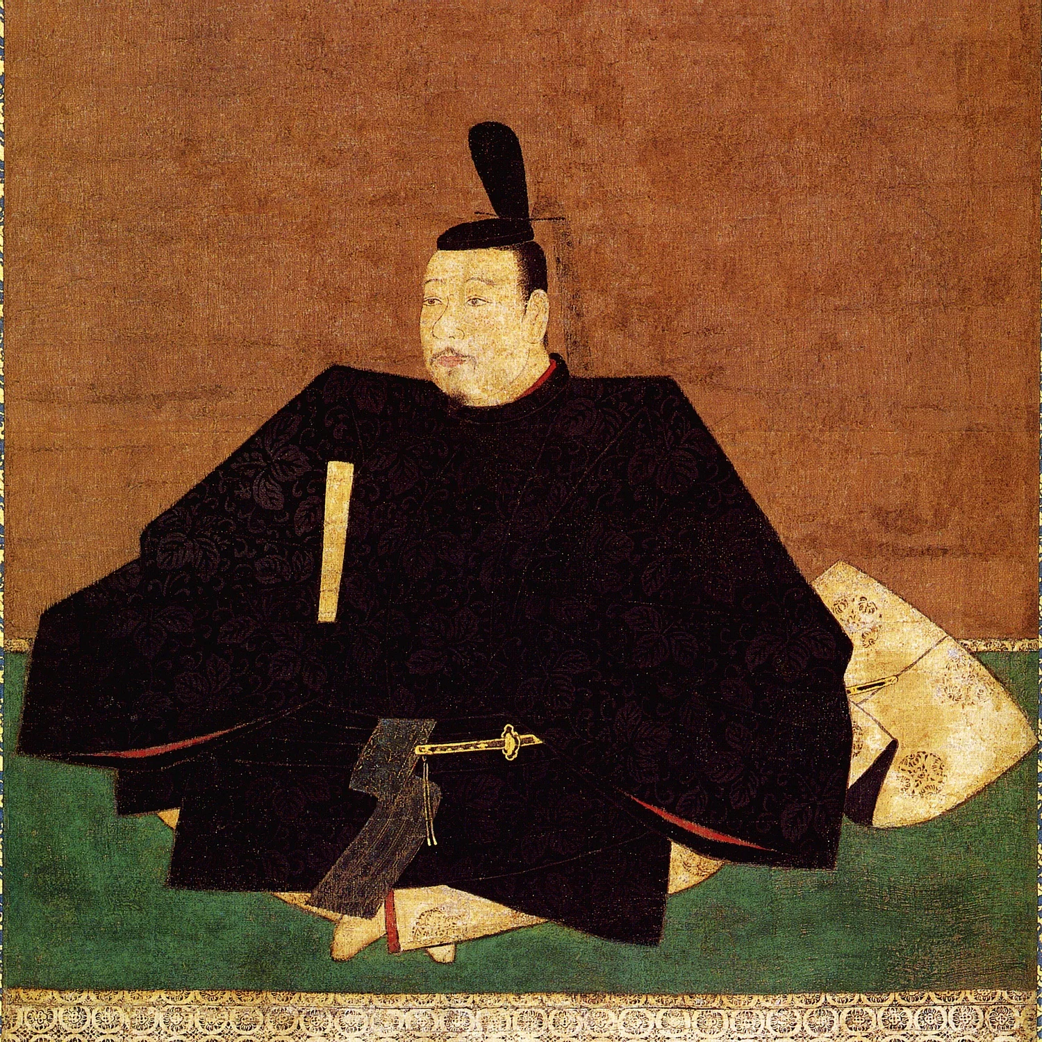 seated man in black with a sword
