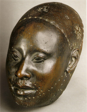 A realistic bronze sculpture of a face.