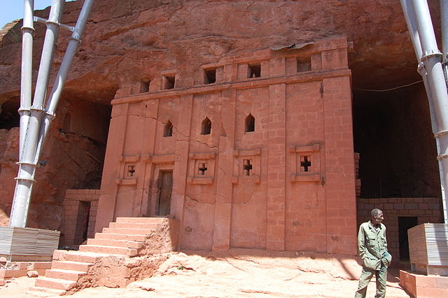 Exterior view of the entrance, which is carved directly into the rock. A giant portion of the uncarved rock sits atop the entrance.