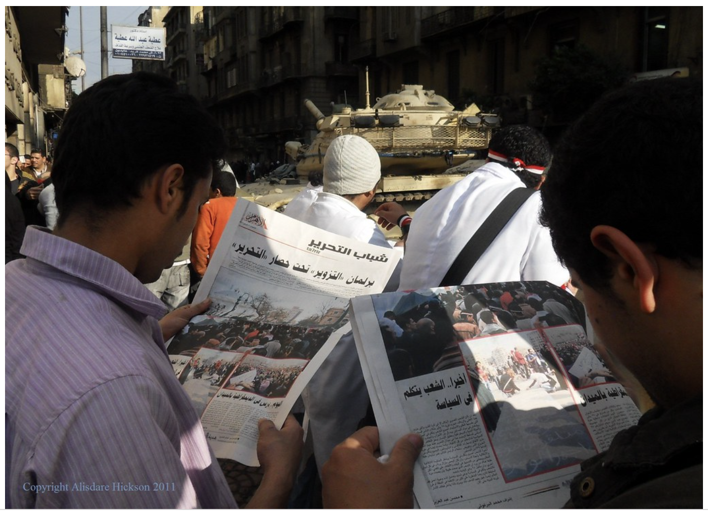 two men read newspapers
