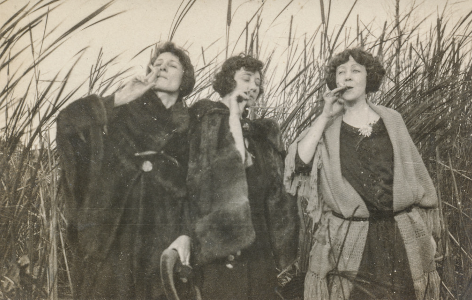 three women in fur coats smoking