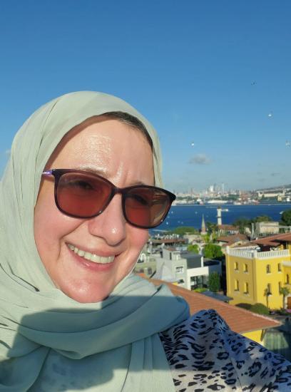 hana kassas is wearing a green hijab and the blue see in the back.