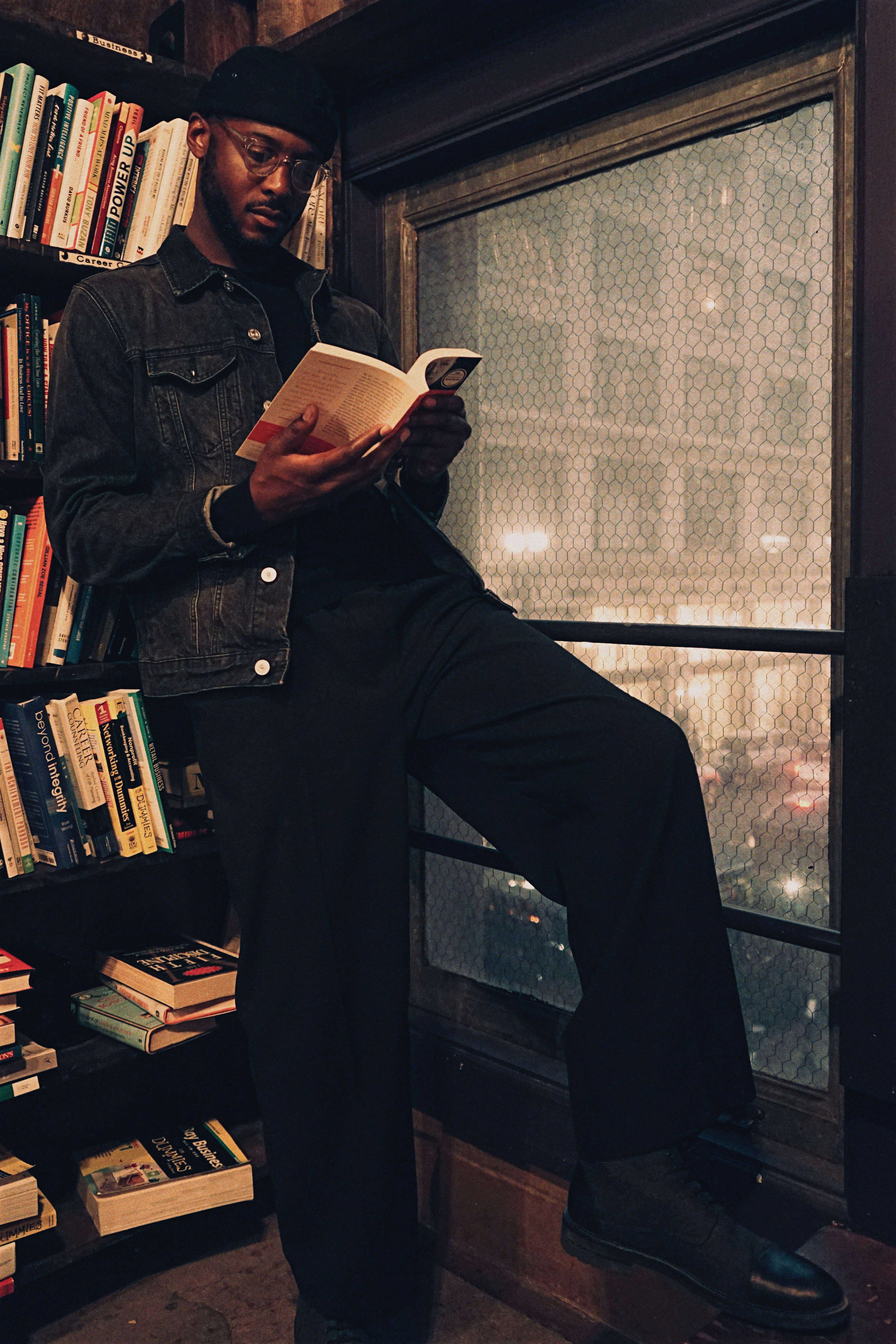 Black man reading a book in a library