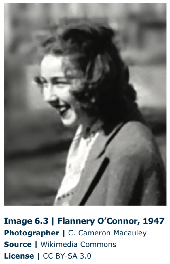 Fotografía en blanco y negro de Flannery O'Connor, una mujer blanca con el pelo rizado sonriendo a alguien o algo fuera de cámara y vistiendo un blazer