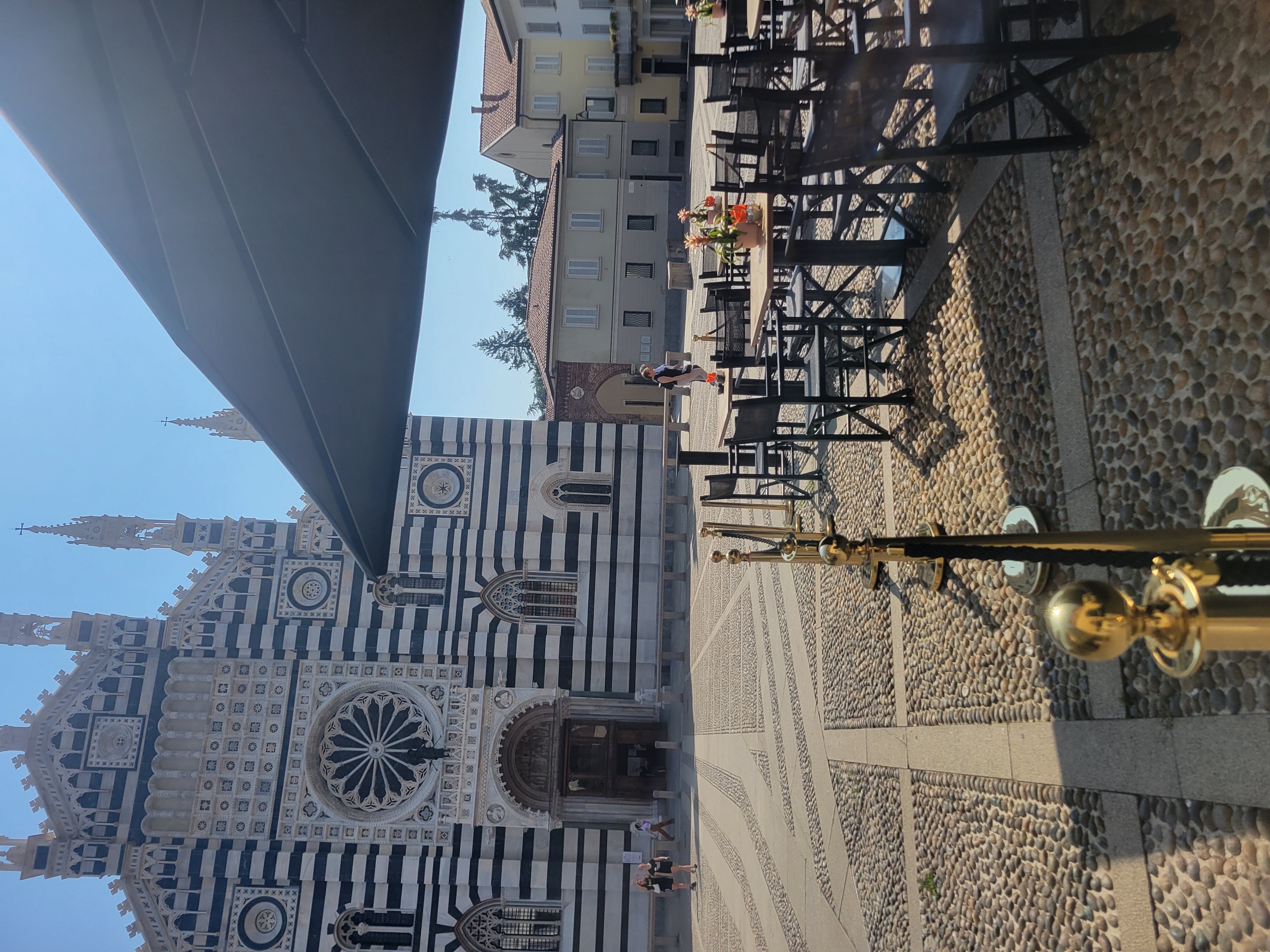 Outdoor coffee tables in an Italian piazza in front of a duomo (church) in Monza.