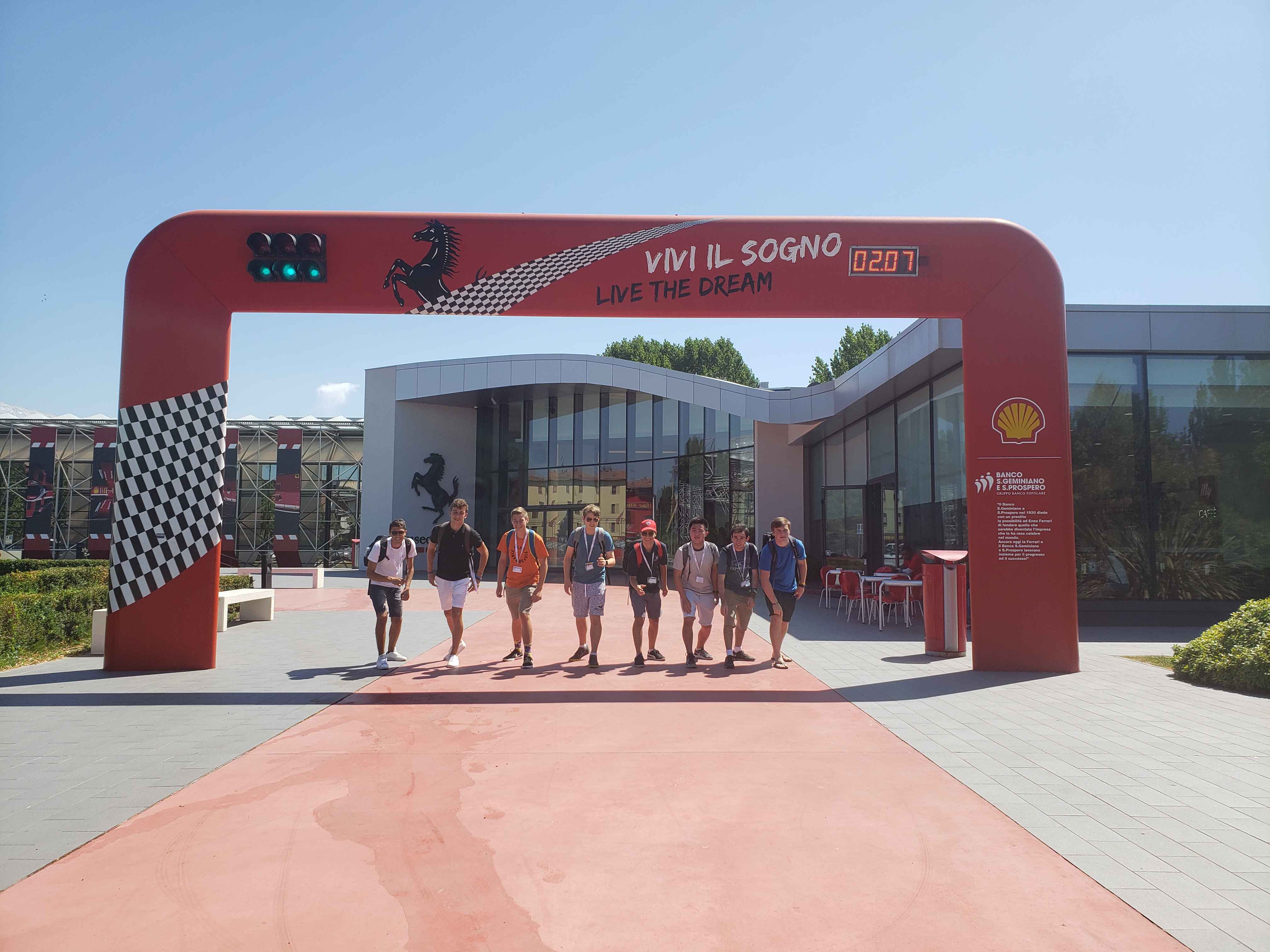 Eight teens lined up, ready to run under the Ferrari headquarters starting gates