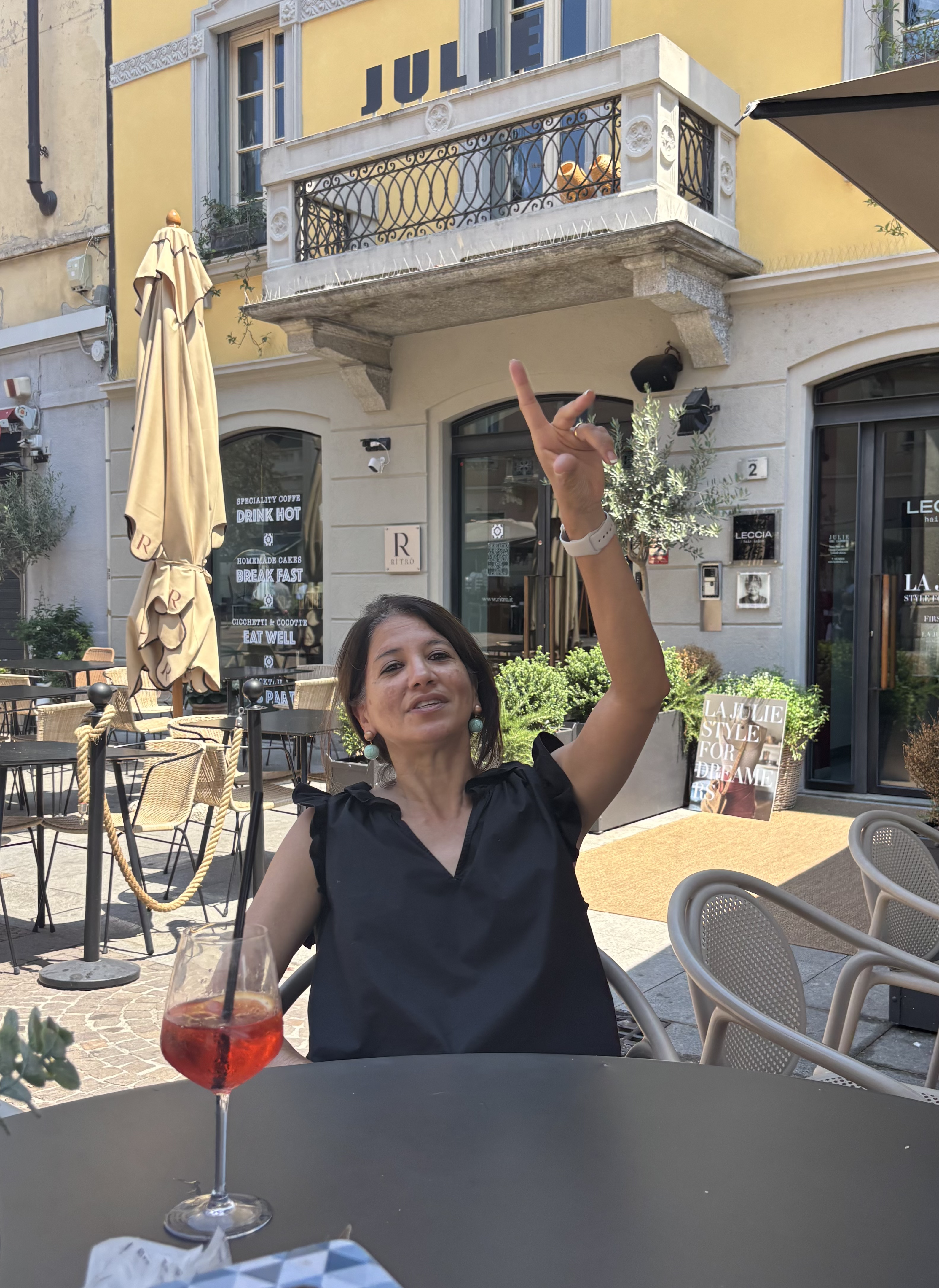 A woman uses her hand and facial expression to signal the waiter.