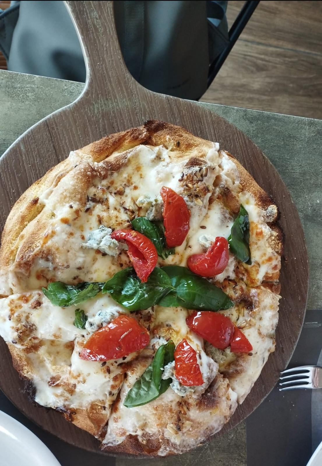 A freshly baked Italian pizza topped with mozzarella, tomatoes, and basil.