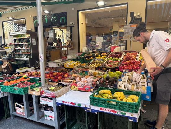 Fruttivendolo stall with neatly stacked fruits and vegetables in baskets and wooden crates.