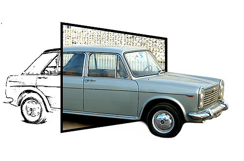 Image of a car emerging through a square set at an angle to the viewer. The front end of the car, outside the square, is a photo-real image of a Renault. The back end, on the other side of the square, is a line drawing of the back part of the car.