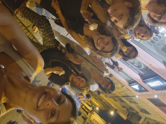 Eight women smiling in downtown Monza while holding ice cream