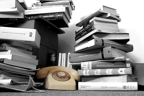 Black and white photo of a stack of books and textbooks.