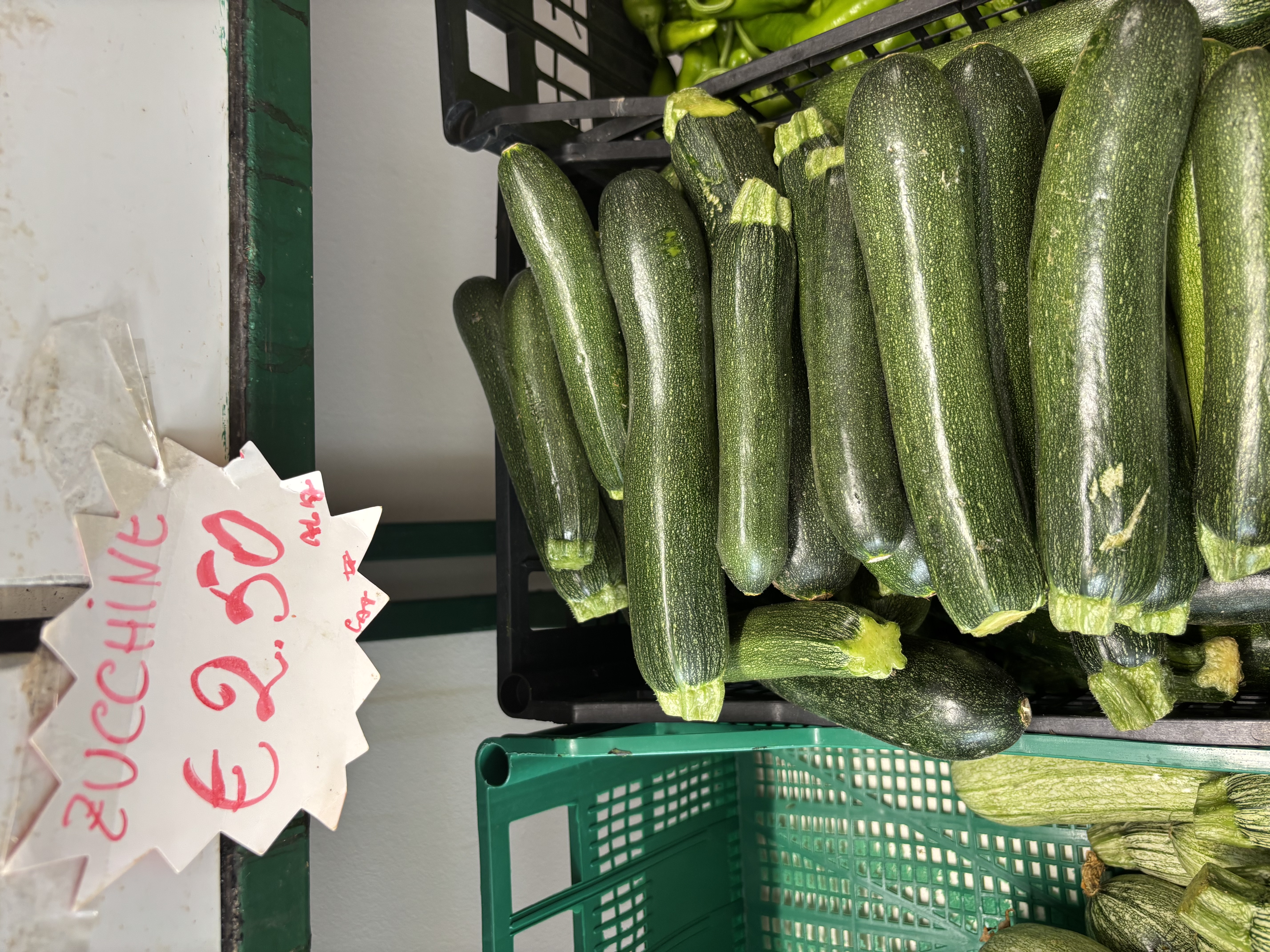 A display of fresh zucchinis grouped in a basket, with a price tag reading &euro;2.50.