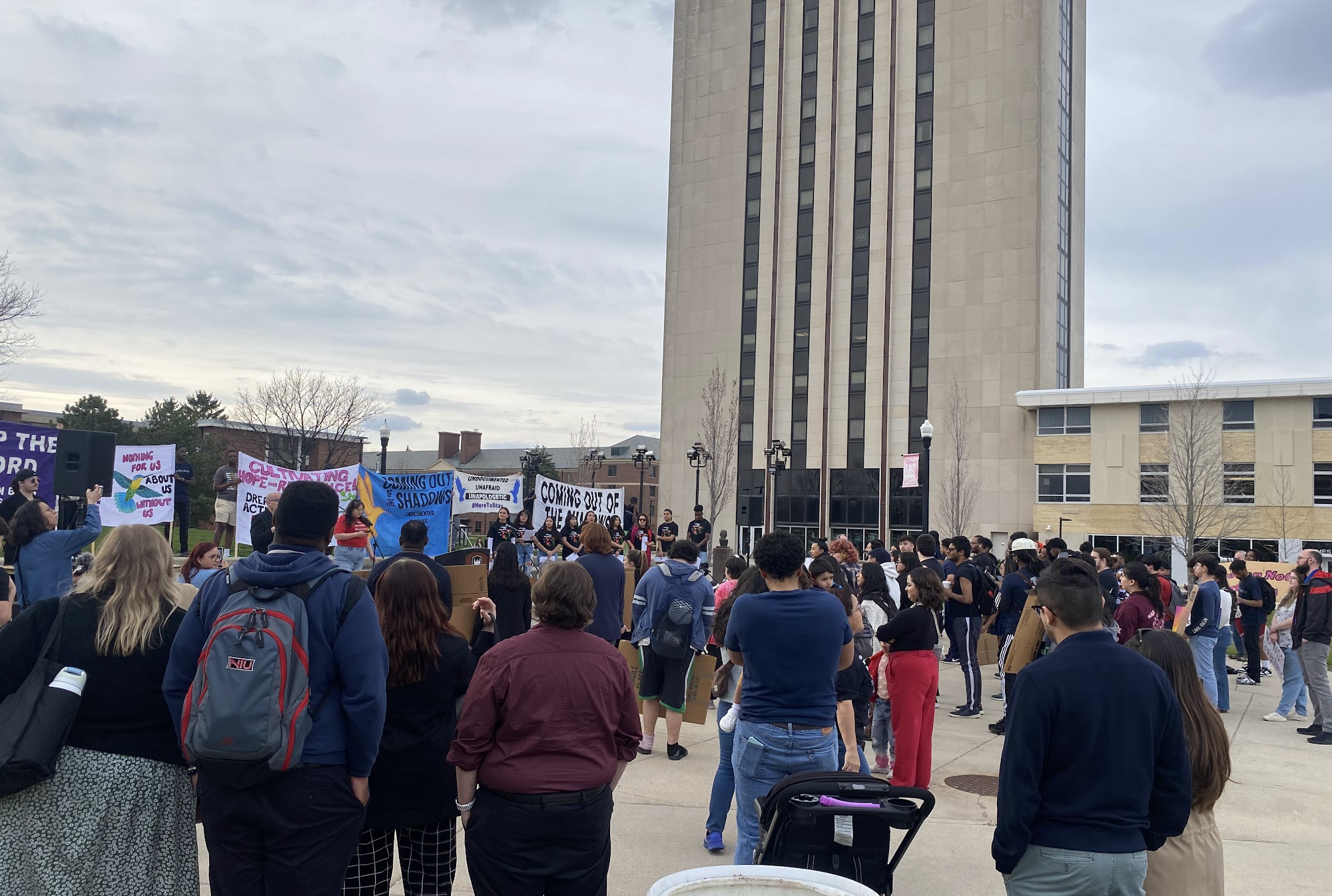 foto de un grupo grande de personas con pancartas en el campus de NIU