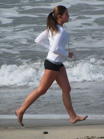 A woman running while wearing headphones.